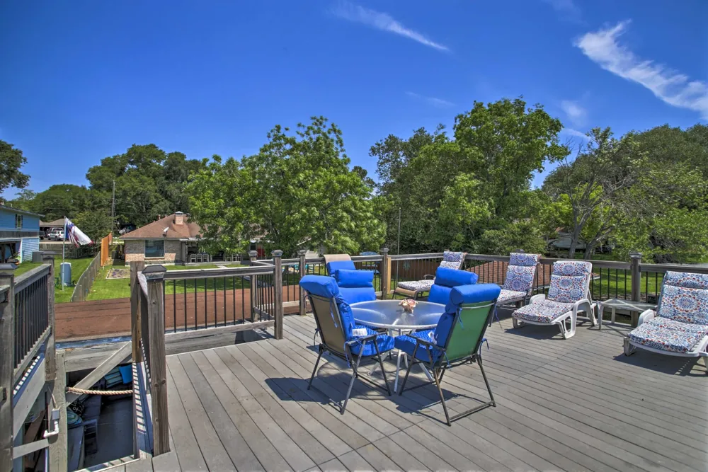 Open-air deck with wood railings and blue outdoor seating