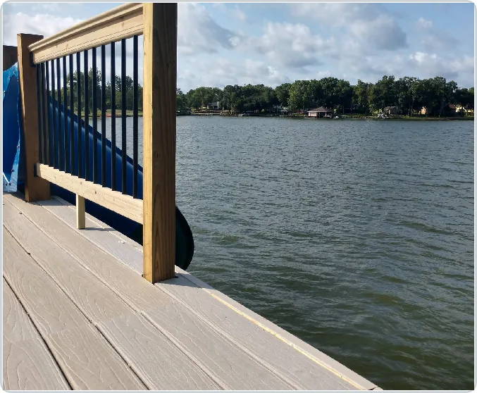 Completed waterfront deck with railing and a gate overlooking the lake