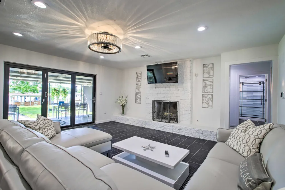 Renovated living room with a fireplace, large windows and recessed lighting